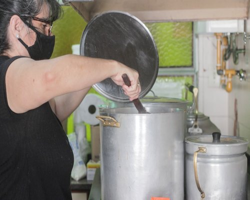 Persona haciendo una pausa activa tomando agua fresca en su cocina