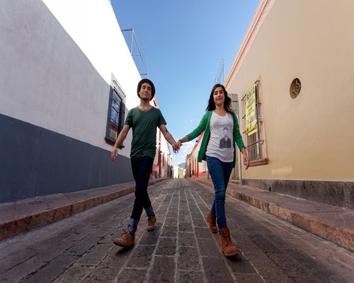 Pareja caminando tranquilamente por calles empedradas de un pueblo mágico en México